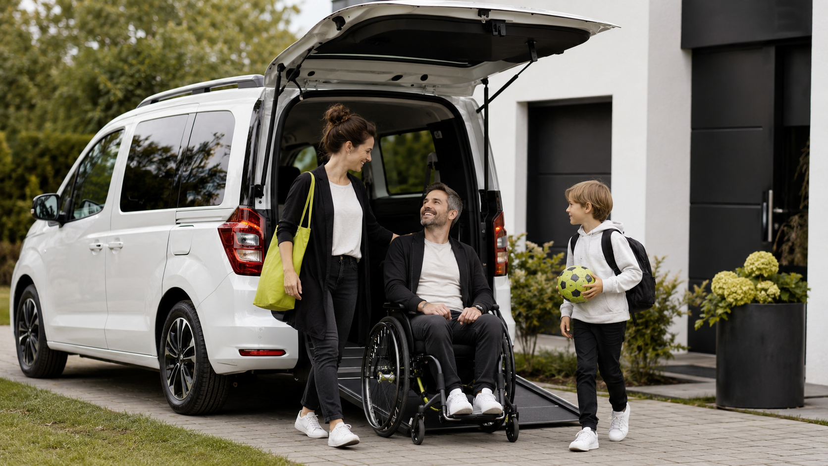 Vater im Rollstuhl mit seiner Frau und seinem Sohn vor einem Rollstuhlauto.