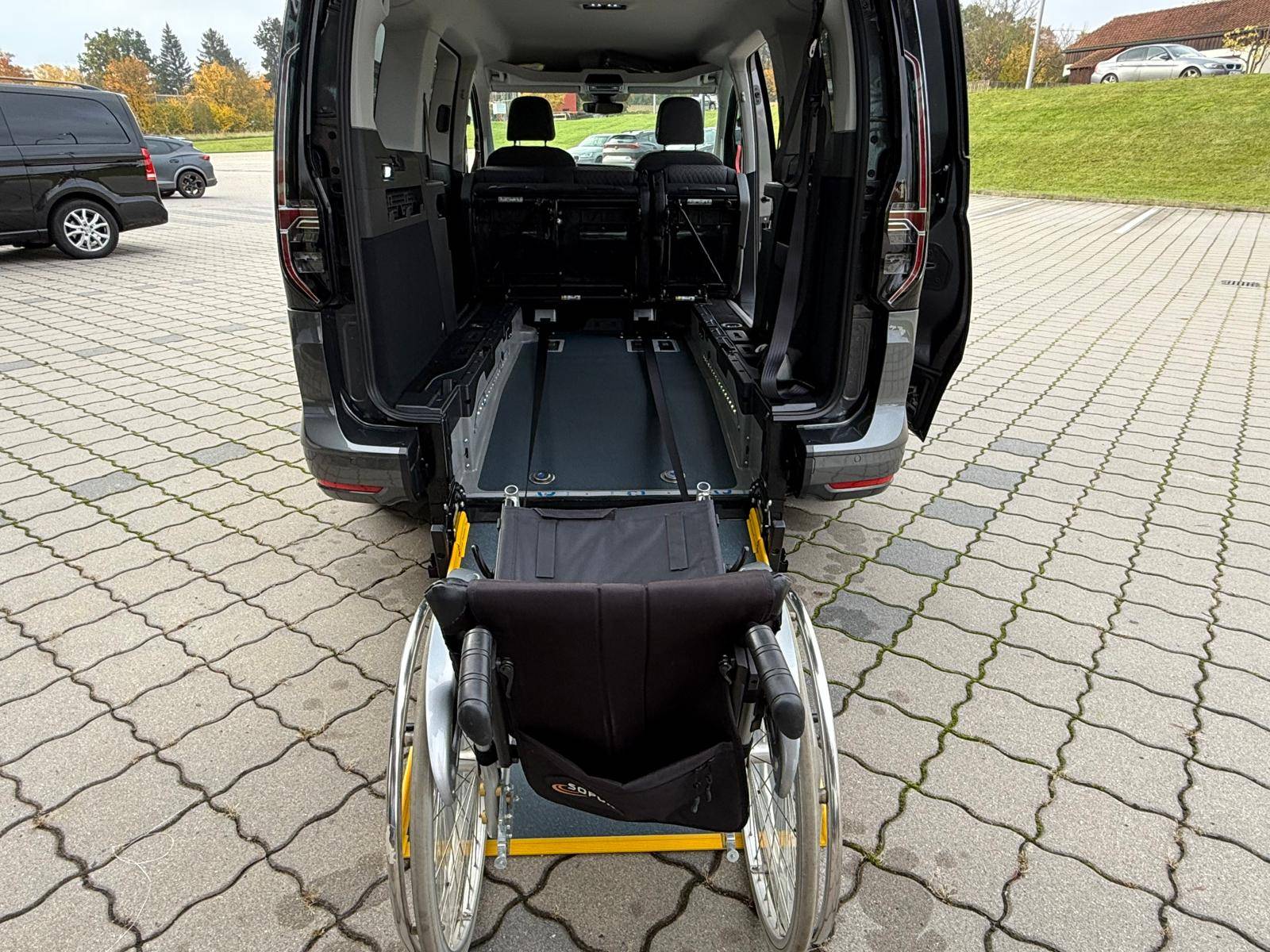 VW Rollstuhlautos - VW Caddy - Heckansicht mit geöffneter Heckklappe und Rollstuhl